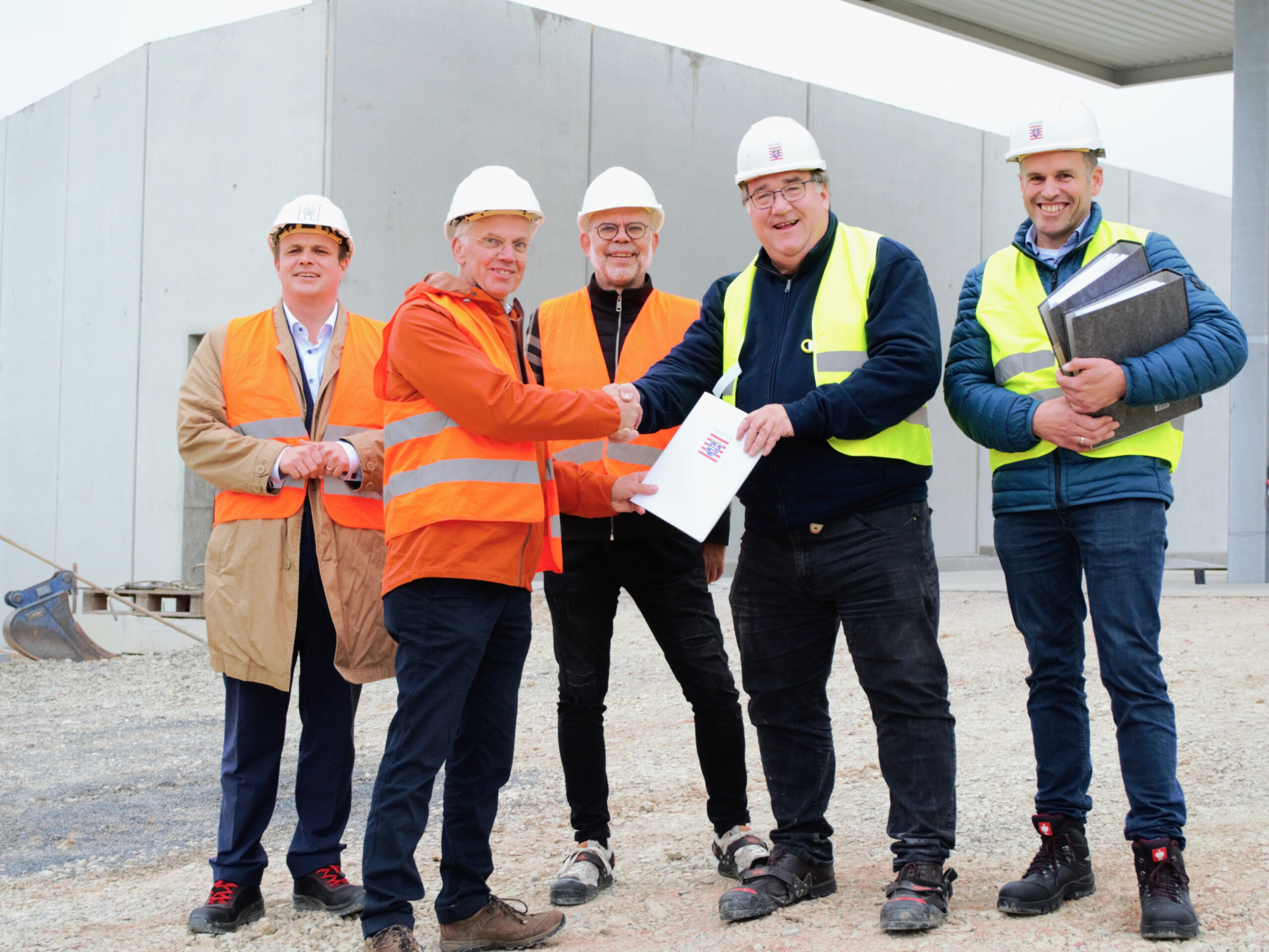 Regierungspräsident Mark Weinmeister übergibt den Genehmigungsbescheid an Dr. Jochen Ahn. Die Personen von links: Bürgermeister Benjamin Tschesnok (Stadt Hünfeld), Dr. Jochen Ahn (ABO Energy), Dr. Thomas Nietsch (ABO Energy), Regierungspräsident Mark Weinmeister (Regierungspräsidium Kassel) und Verfahrensleiter Christian Rippl (Regierungspräsidium Kassel).